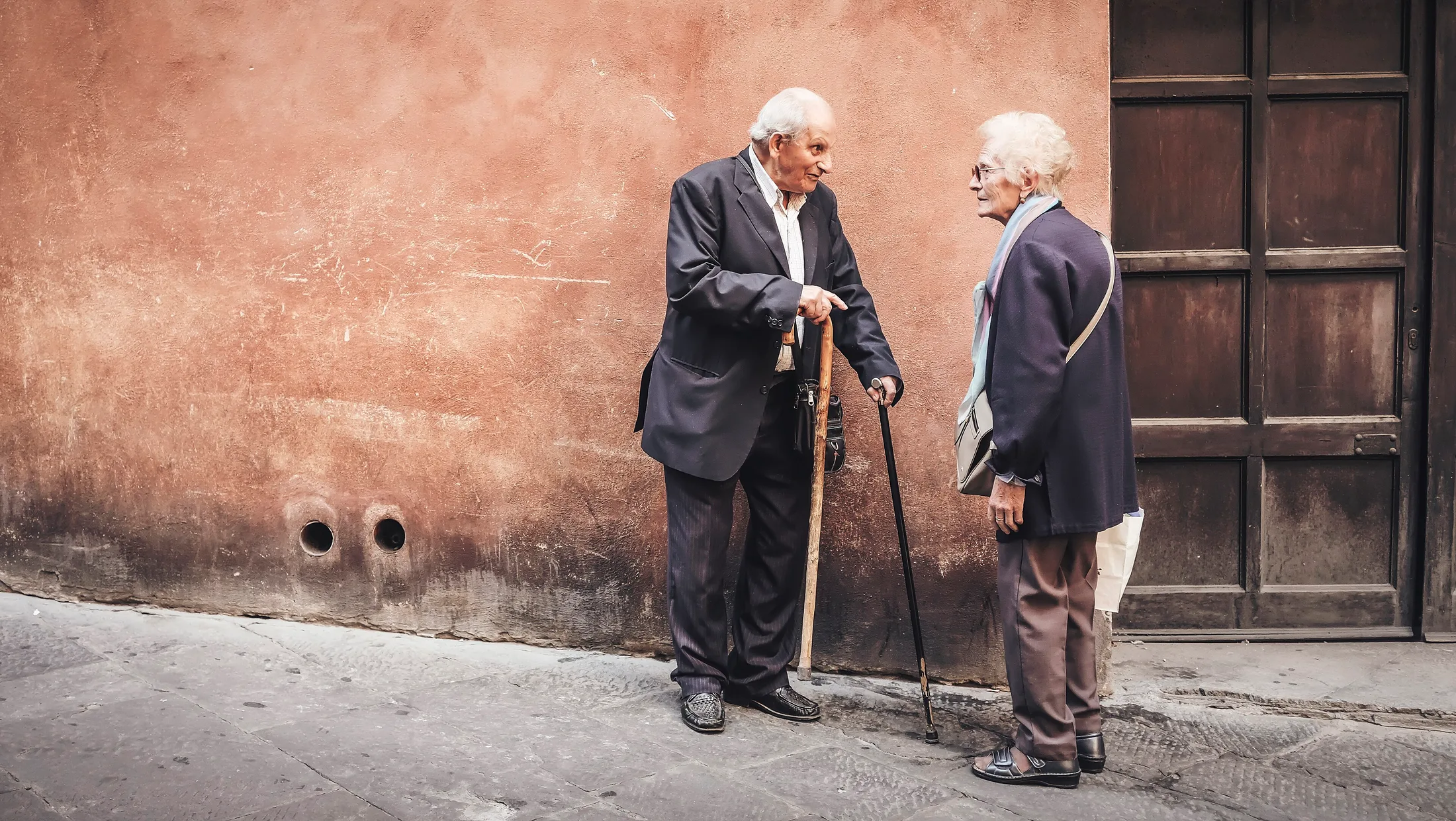 Dos personas mayores conversando en la calle