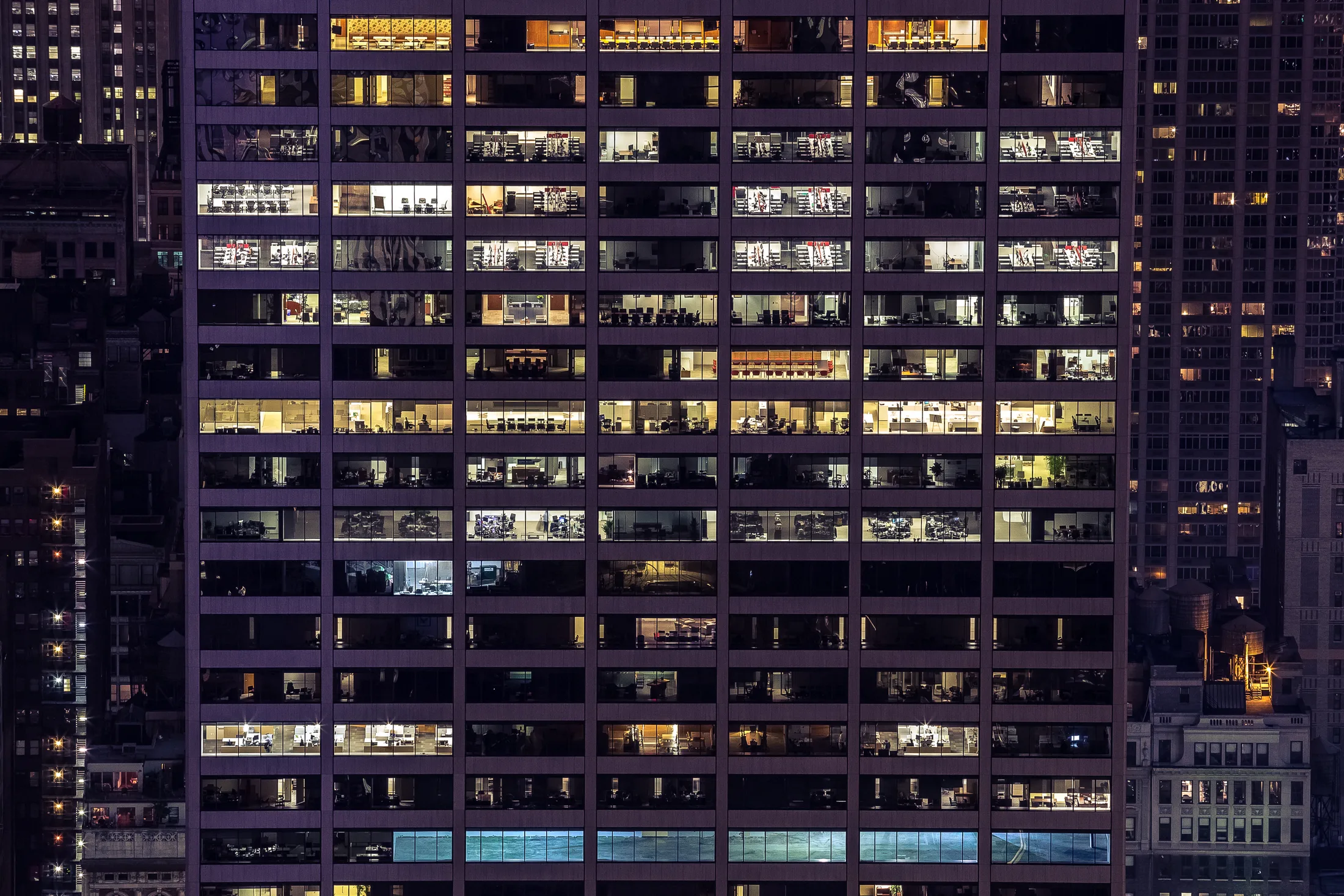 Fachada iluminada de un edificio de oficinas al anochecer