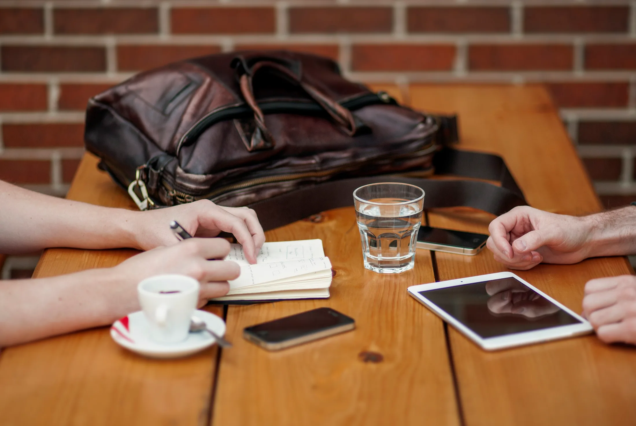 Dos personas revisando notas y documentacion sobre una mesa de trabajo